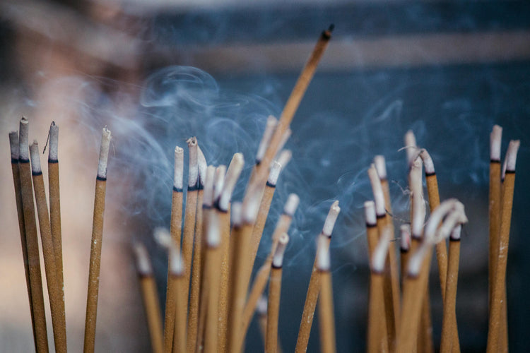 Incense sticks with smoke against a blurred background